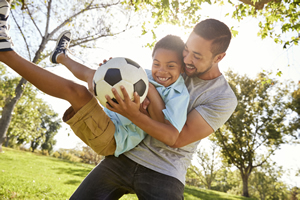 Man holding a child and a ball